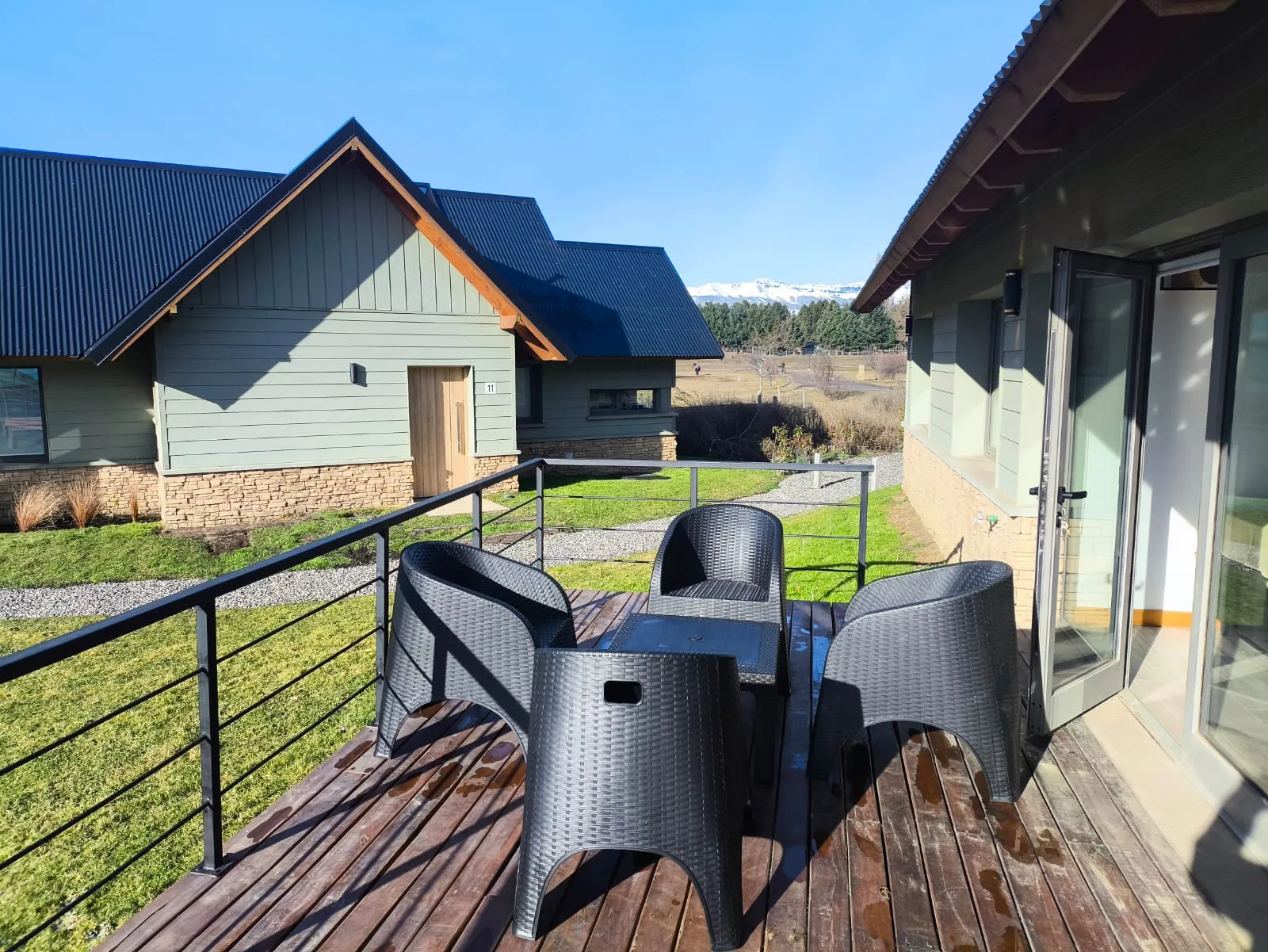 Deck privado de madera con sillones y vista a los cerros nevados