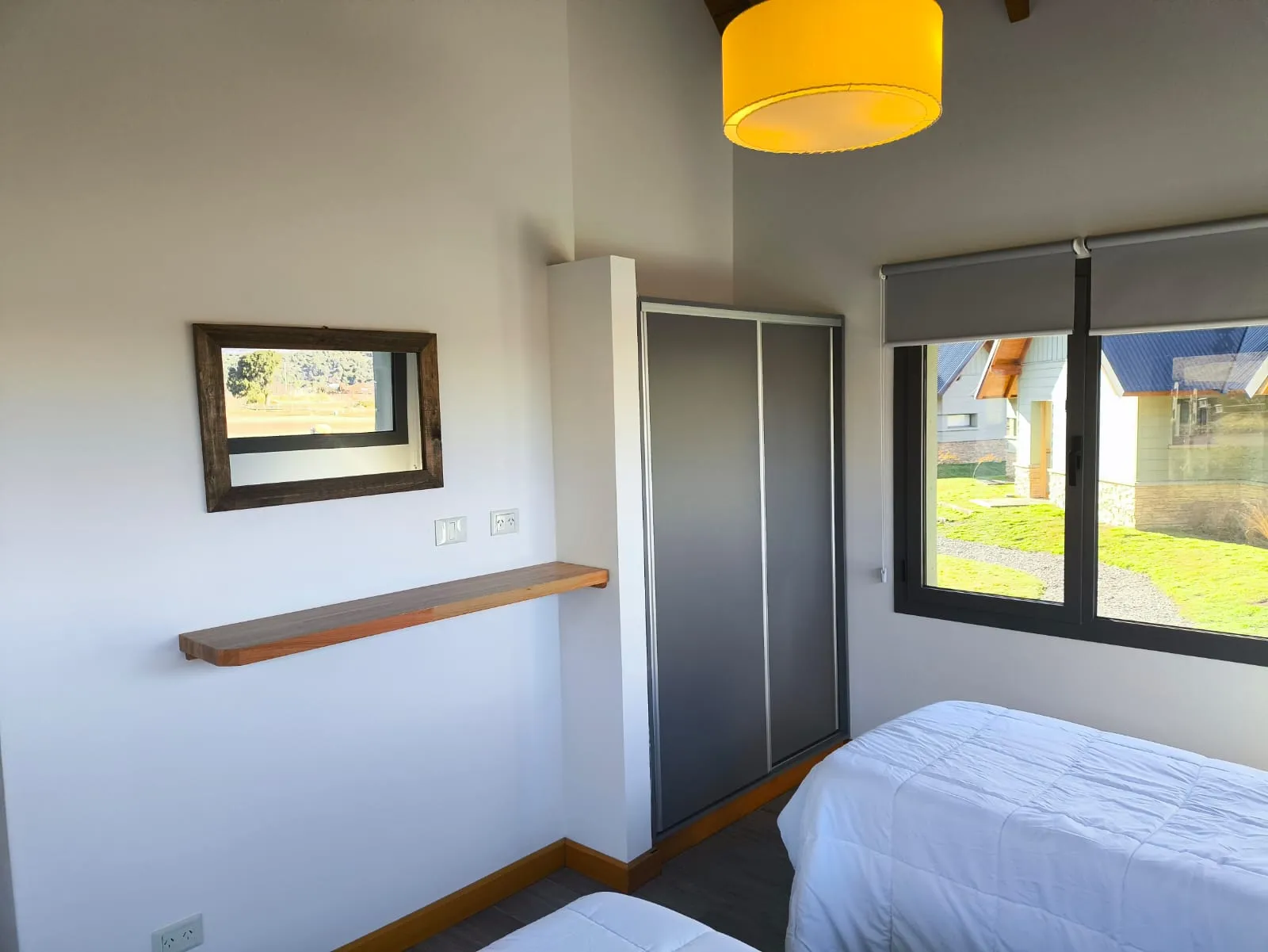 Dormitorio twin con placard y ventana al jardín