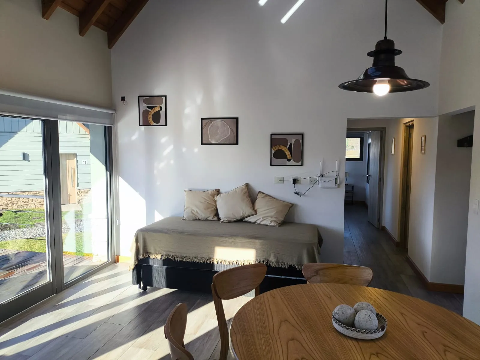 Living comedor integrado de la cabaña con sofá cama y techo alto